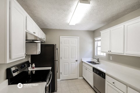 a kitchen with white cabinets and a stove and a refrigerator