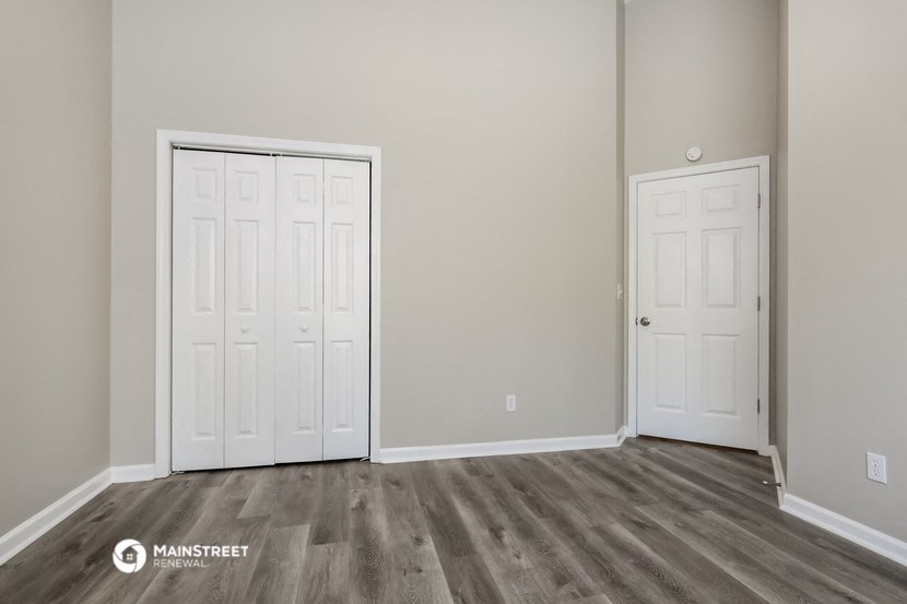 a bedroom with two doors and a door to a closet