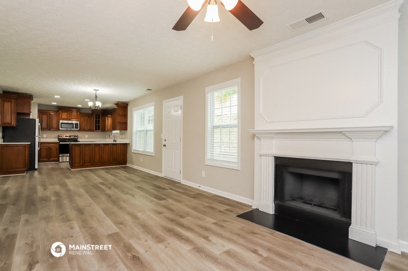 a living room with a fireplace and a kitchen