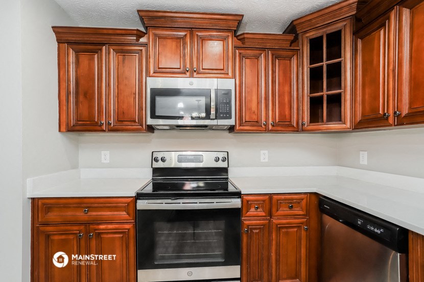 a kitchen with wood cabinets and a stove and a microwave