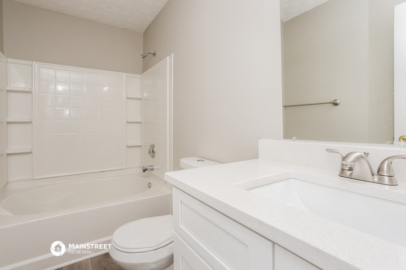 a white bathroom with a tub and a sink and a toilet