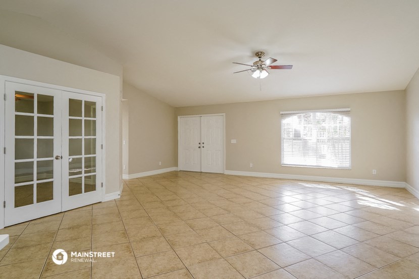 an empty living room with a ceiling fan