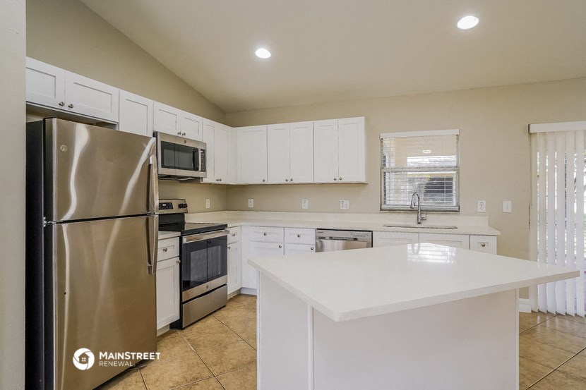a kitchen with white cabinets and stainless steel appliances and a white counter top