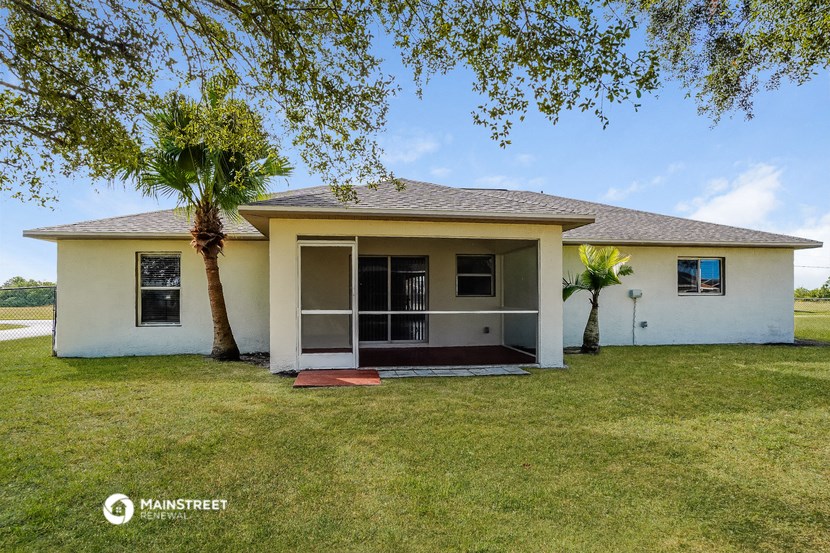 a small white house with a palm tree in the yard