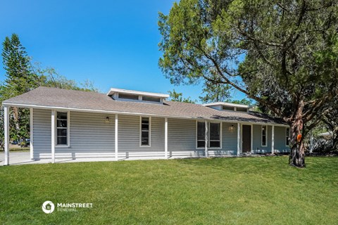 a white house with a tree in front of it