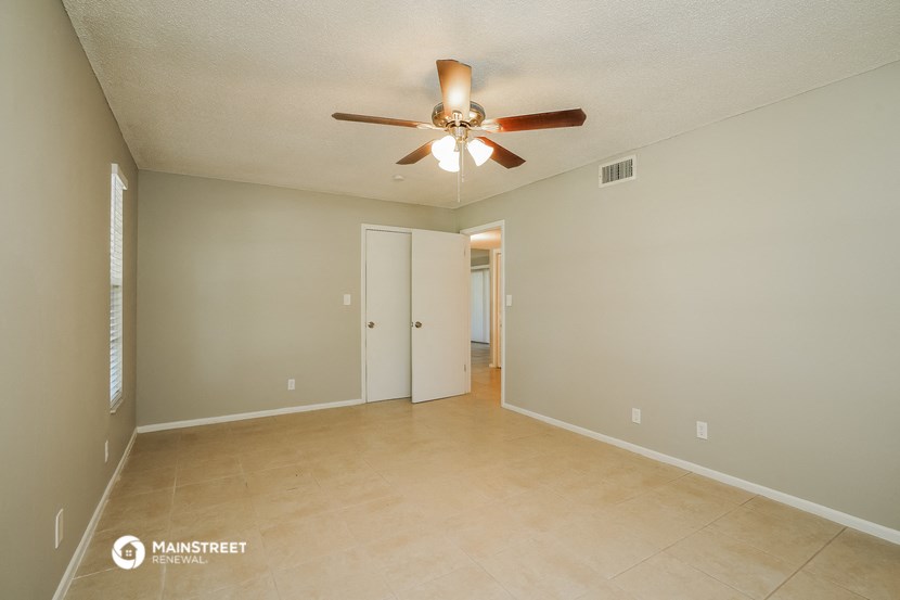 the spacious living room with ceiling fan and tile flooring