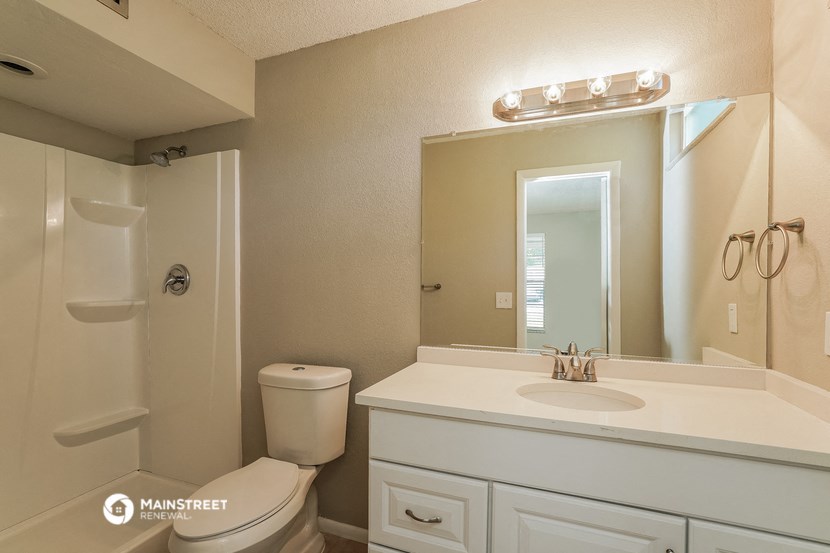 a bathroom with a sink toilet and a mirror