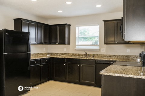 a kitchen with black cabinets and granite counter tops
