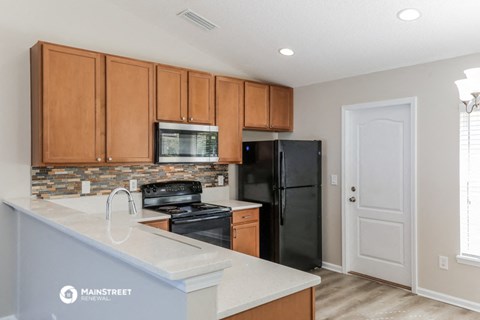 a kitchen with black appliances and wooden cabinets