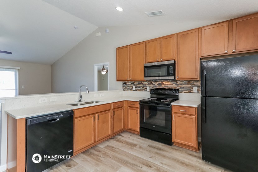 a kitchen with black appliances and wooden cabinets
