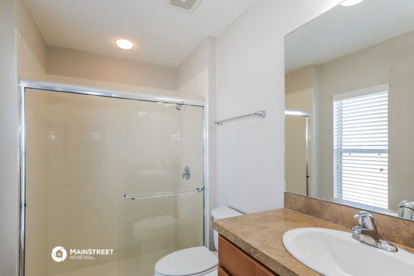 a bathroom with a shower and a sink and a toilet