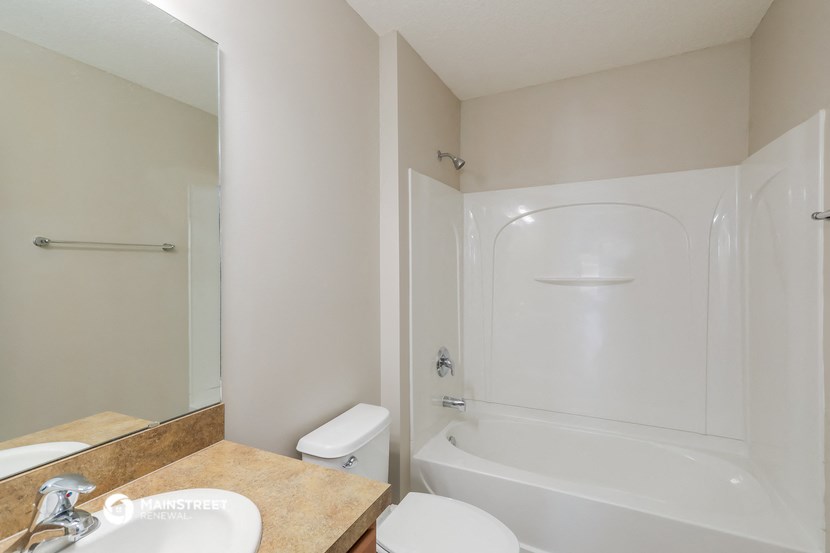 a bathroom with a tub and a sink and a mirror