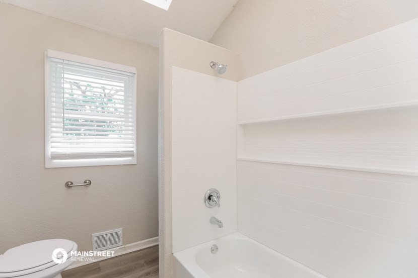 a bathroom with a tub and a toilet and a sink