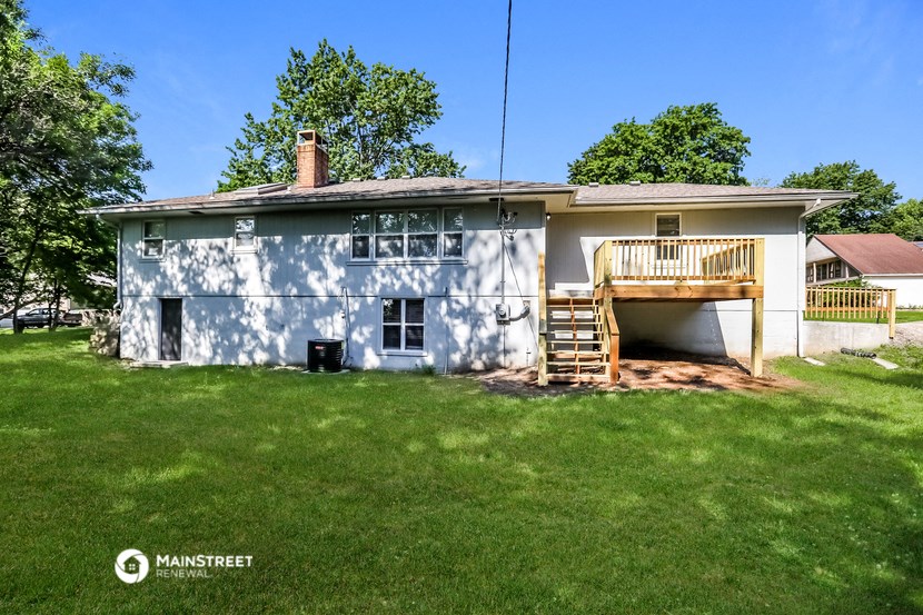 a white house with a deck on the back of it