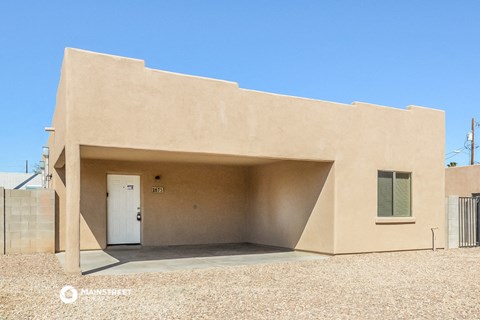 a desert house with a white door and a blue sky