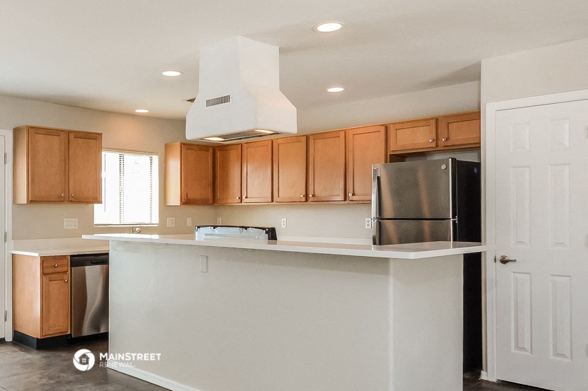 a kitchen with wood cabinets and a white counter top