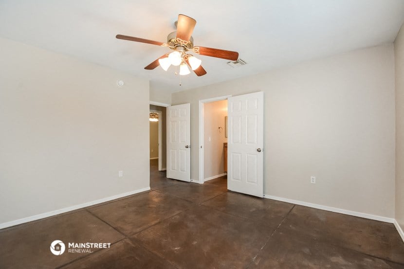 the spacious living room with ceiling fan and tile flooring