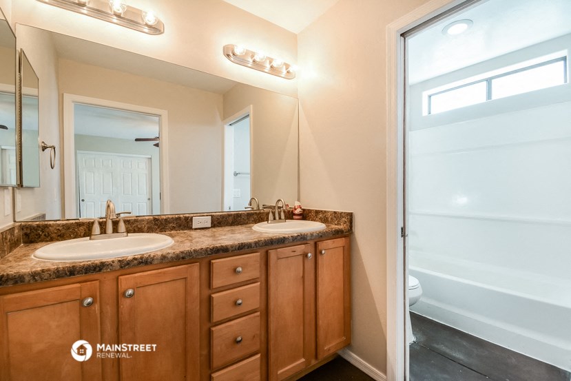 a bathroom with two sinks and a shower and a mirror