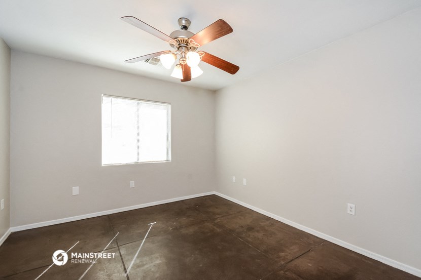 the bedroom has a ceiling fan and vinyl flooring