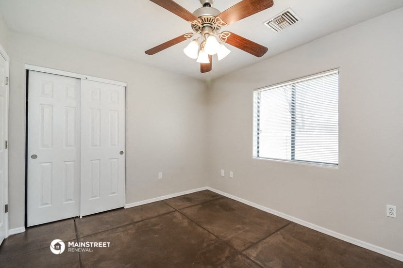 the bedroom has a ceiling fan and a door to the closet