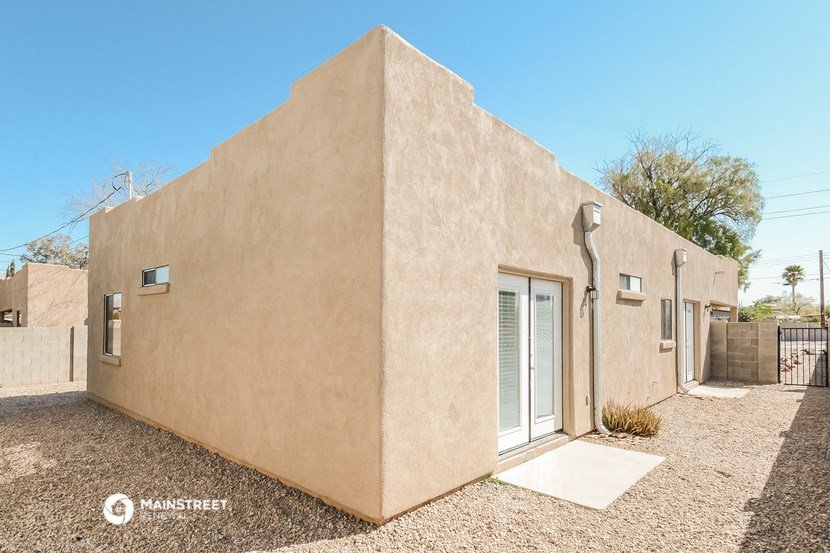 a beige house with a sliding glass door and a patio
