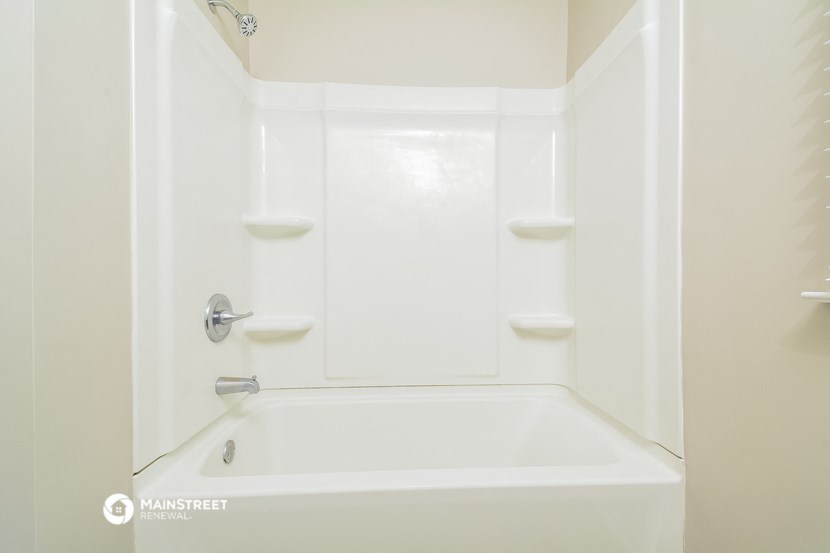 a white bathroom with a white tub and white walls