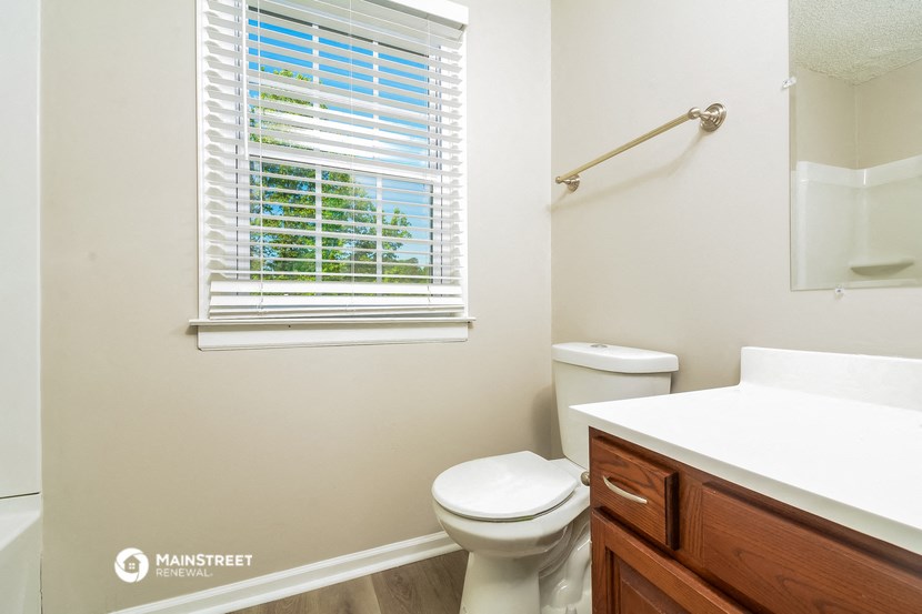 a bathroom with a toilet and a sink and a window