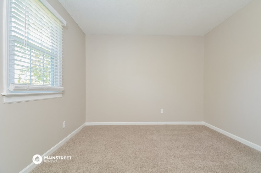 a bedroom with a carpeted floor and a window