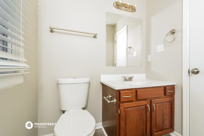 a bathroom with a toilet and a sink and a mirror