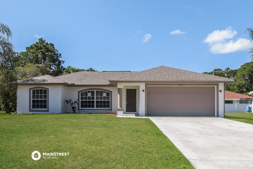 a white house with a lawn and a garage door