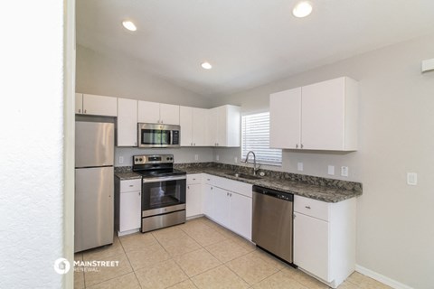 a kitchen with white cabinets and stainless steel appliances