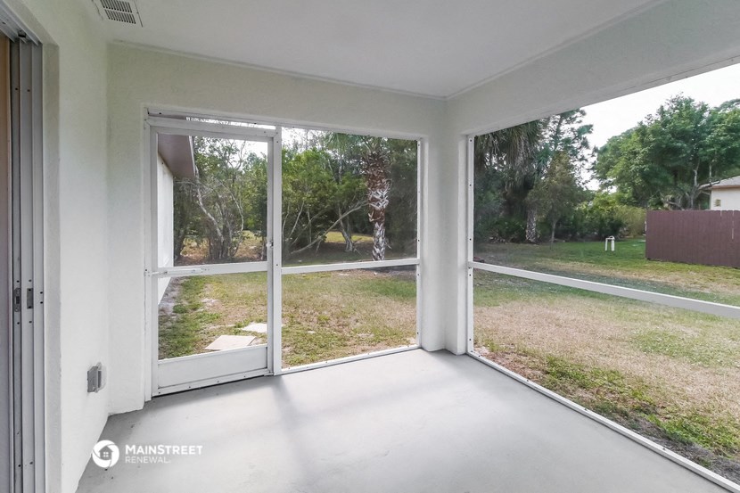 a living room with large windows and a view of the yard