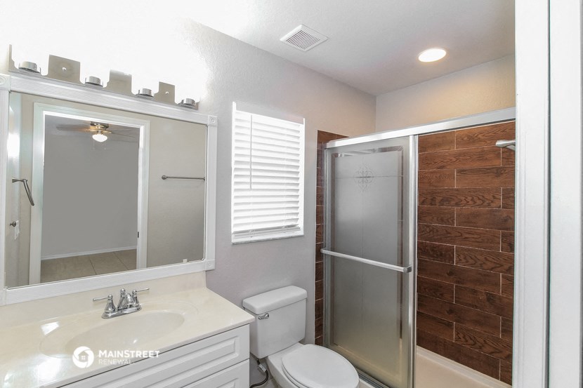 a bathroom with a shower and a sink and a toilet