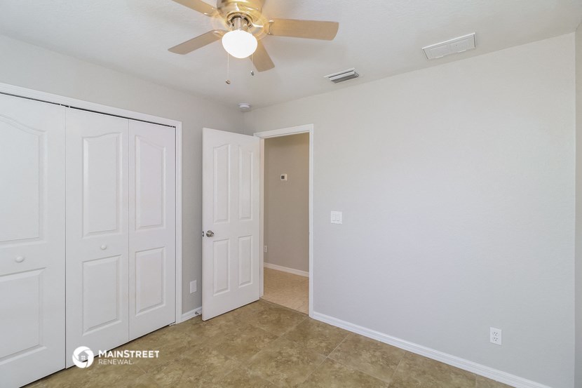 a bedroom with two closets and a ceiling fan