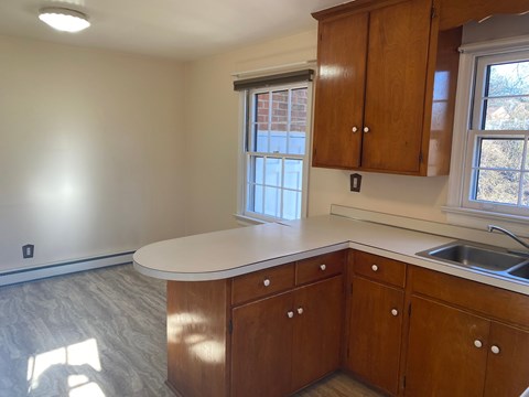 A kitchen with wooden cabinets and a white countertop.