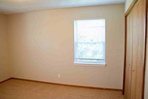 a bedroom with a window and a closet