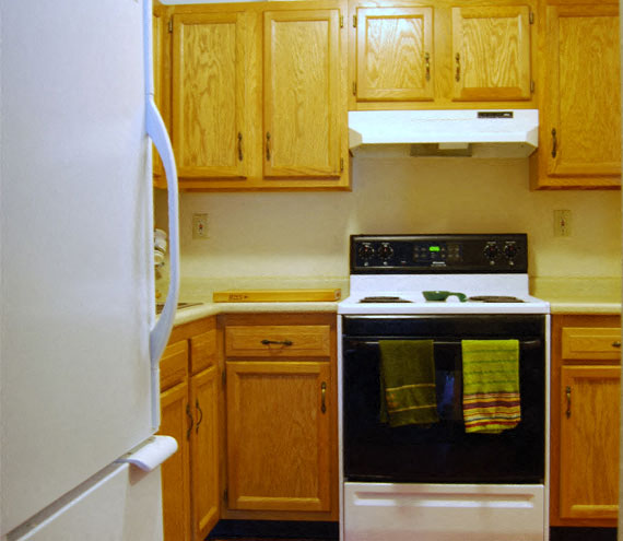 A kitchen with a white refrigerator and a white stove with an oven.