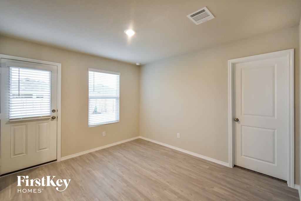 an empty room with a white door and a window