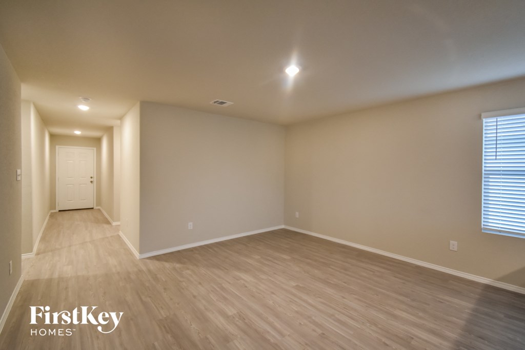 a spacious living room with wood flooring and a white door
