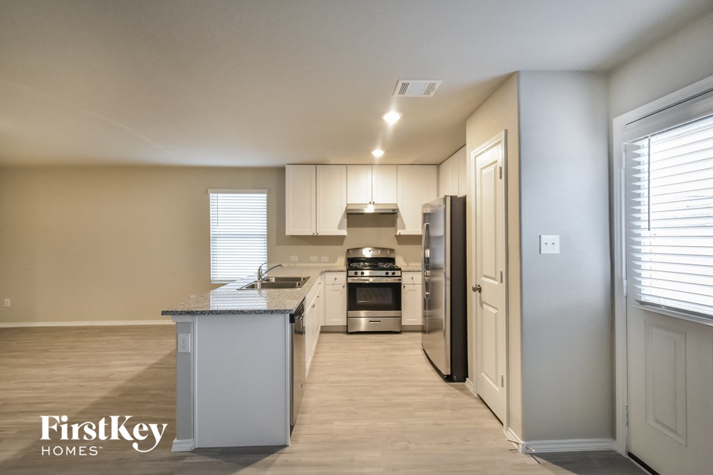 a large kitchen with white cabinets and stainless steel appliances