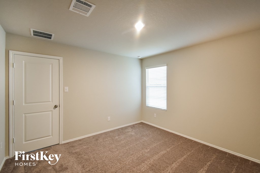 an empty room with a white door and a window
