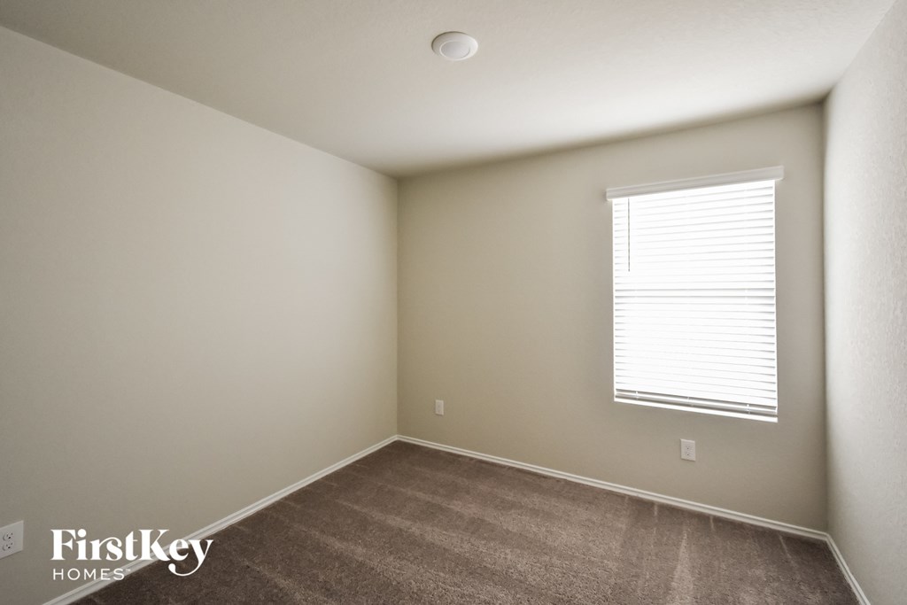 a bedroom with a carpeted floor and a window