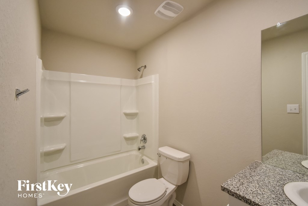 a bathroom with a toilet and a tub and a sink