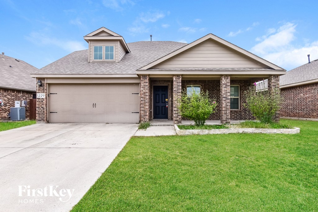 a home with a driveway and lawn in front of it