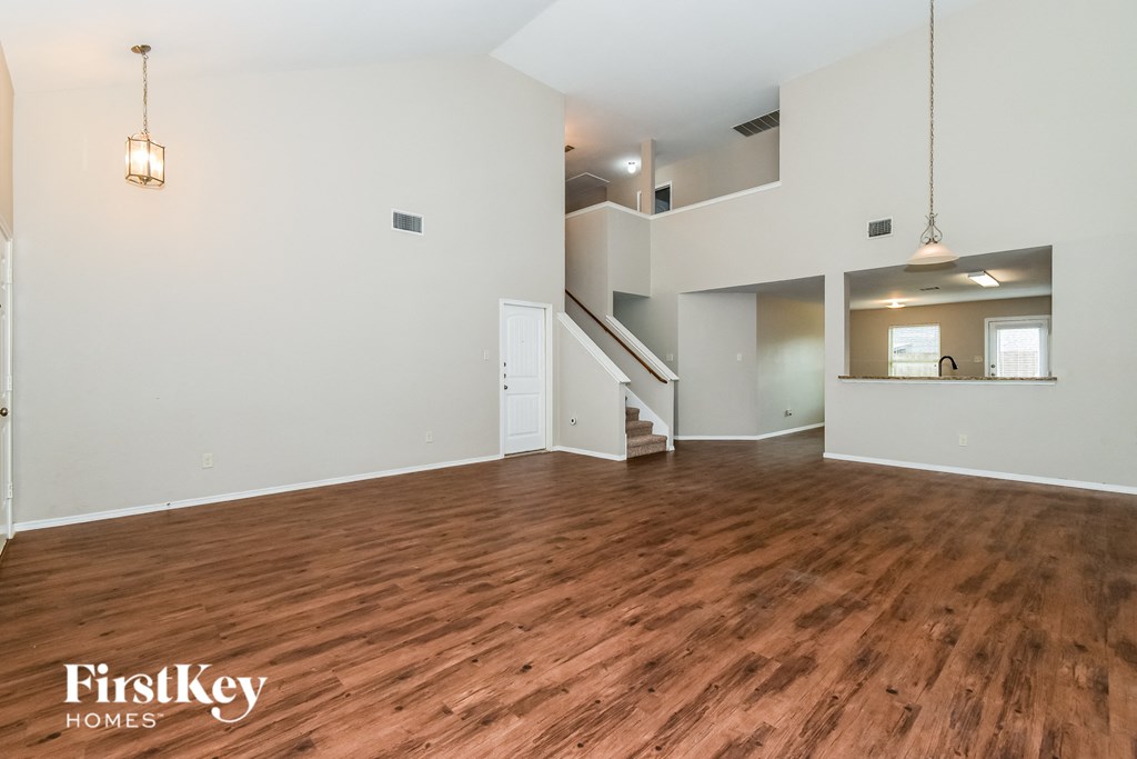 a living room with a hard wood floor and white walls