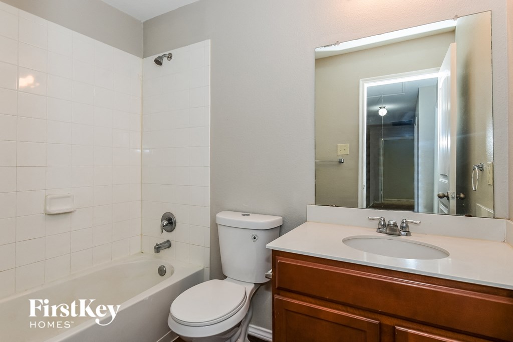 a bathroom with a sink toilet and a mirror
