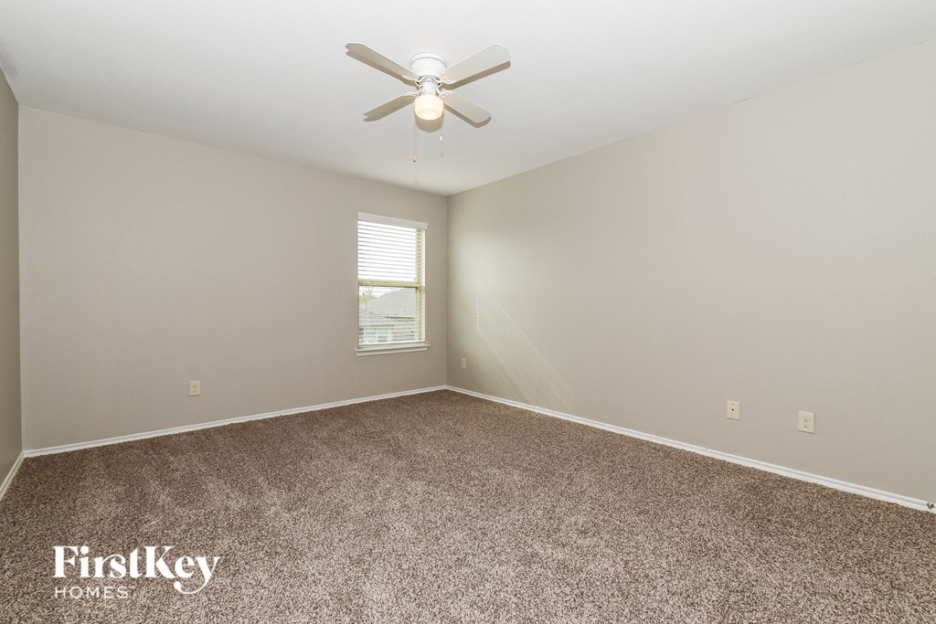 a bedroom with carpet and a ceiling fan