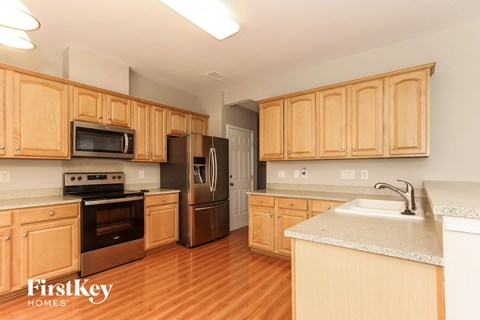 A kitchen with wooden cabinets and a stainless steel refrigerator.