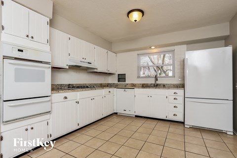 A kitchen with white cabinets and appliances.