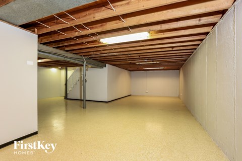 A spacious room with wooden ceiling and white walls, with a FirstKey HOMES logo on the bottom left.